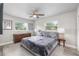 Well-lit bedroom with a ceiling fan, two windows, and matching nightstands at 1530 Picardy Cir, Clearwater, FL 33755