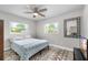 Bright bedroom with patterned carpet, ceiling fan, comfortable queen bed, and ample natural light at 1530 Picardy Cir, Clearwater, FL 33755