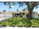 Charming single-story home boasts a well-manicured lawn and mature shade tree at 1530 Picardy Cir, Clearwater, FL 33755