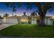 Charming single-story home at dusk with a well-manicured lawn, mature shade tree, and a two-car garage at 1530 Picardy Cir, Clearwater, FL 33755