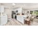 Modern white kitchen featuring stainless steel appliances, a breakfast bar, and an open layout for entertaining at 1530 Picardy Cir, Clearwater, FL 33755
