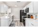 Contemporary white kitchen with stainless steel appliances and stylish backsplash for meal preparation and entertaining at 1530 Picardy Cir, Clearwater, FL 33755