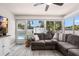 Bright living room with large windows, gray sofa, and view of the pool at 1530 Picardy Cir, Clearwater, FL 33755