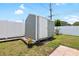 Backyard shed surrounded by green grass and a white picket fence, offering extra storage space at 1530 Picardy Cir, Clearwater, FL 33755