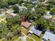 Aerial view of a home surrounded by lush trees in a quiet neighborhood, identified with a red arrow at 1573 Cumberland Ln, Clearwater, FL 33755