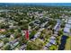 Neighborhood aerial view with the house identified by a red arrow, amidst trees and residential buildings at 1573 Cumberland Ln, Clearwater, FL 33755