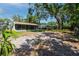 Spacious backyard featuring a screened lanai, mature trees, and ample space for outdoor enjoyment at 1573 Cumberland Ln, Clearwater, FL 33755
