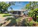 Expansive backyard featuring a screened lanai, mature trees, and ample space for outdoor activities and relaxation at 1573 Cumberland Ln, Clearwater, FL 33755