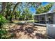 A large backyard with trees and a covered patio area at 1573 Cumberland Ln, Clearwater, FL 33755