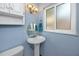 This bathroom has a pedestal sink and a framed window at 1573 Cumberland Ln, Clearwater, FL 33755