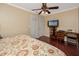 A bedroom featuring dark wood floors, bright window, ceiling fan and television at 1573 Cumberland Ln, Clearwater, FL 33755