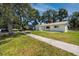 Lovely home with well-kept lawn, mature trees, a sidewalk, and a blue garage door at 1573 Cumberland Ln, Clearwater, FL 33755