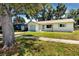 Lovely one-story home with a well-kept lawn, a light blue garage door, and a serene residential setting at 1573 Cumberland Ln, Clearwater, FL 33755