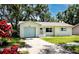 Charming single-story home featuring a well-manicured lawn, blue garage door and coordinated trim at 1573 Cumberland Ln, Clearwater, FL 33755