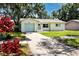 Charming one-story home featuring a well-maintained front yard, a light blue garage door, and a welcoming entrance at 1573 Cumberland Ln, Clearwater, FL 33755