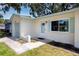 Charming home featuring a well-manicured lawn, blue front door, and coordinated light exterior at 1573 Cumberland Ln, Clearwater, FL 33755
