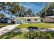 Well-maintained home with a green lawn, light exterior paint, blue garage door and coordinated trim at 1573 Cumberland Ln, Clearwater, FL 33755
