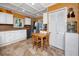 Cozy kitchen with modern appliances, white cabinets, tiled floor, and a dining nook at 1573 Cumberland Ln, Clearwater, FL 33755