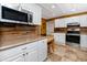 Bright kitchen featuring updated stainless steel appliances, white cabinets, and stylish countertops at 1573 Cumberland Ln, Clearwater, FL 33755
