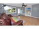 Comfortable living room showcasing wood floors, neutral paint, built-in shelving, and large windows at 1573 Cumberland Ln, Clearwater, FL 33755