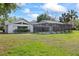 Expansive backyard featuring a screened-in pool area, blending indoor and outdoor living with nature at 16014 Amberly Dr, Tampa, FL 33647
