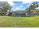 Lush backyard with a screened-in pool enclosure, providing privacy and shade at 16014 Amberly Dr, Tampa, FL 33647