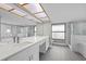 Bright bathroom with double sinks, granite counters, and tiled shower at 16014 Amberly Dr, Tampa, FL 33647