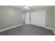 Well-lit bedroom with gray laminate flooring, neutral walls, and closet with bi-fold doors at 16014 Amberly Dr, Tampa, FL 33647