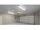 Spacious garage with white door, textured ceiling, and fluorescent lighting at 16014 Amberly Dr, Tampa, FL 33647