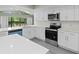 Bright, updated kitchen with white cabinetry, stainless steel appliances, and large window at 16014 Amberly Dr, Tampa, FL 33647