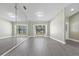 Bright living room boasts hardwood floors, a large mirror wall, and decorative glass paneled doors at 16014 Amberly Dr, Tampa, FL 33647