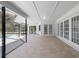 Spacious covered patio featuring tile flooring with multiple access points, offering seamless indoor-outdoor living at 16014 Amberly Dr, Tampa, FL 33647
