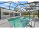 Sparkling screened-in pool with ladder and outdoor seating area, perfect for entertaining and relaxation at 16014 Amberly Dr, Tampa, FL 33647