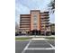 Exterior view of the Ozark condo building with a crosswalk in front and balconies on each level at 16400 Gulf Blvd # 307, North Redington Beach, FL 33708