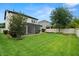 Expansive backyard with lush green grass and a screened-in patio, perfect for outdoor entertaining at 1844 Odiorne Point Ln, Wesley Chapel, FL 33543