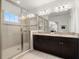 Modern bathroom with double vanity, granite counters, large mirror, and frameless glass shower at 1844 Odiorne Point Ln, Wesley Chapel, FL 33543