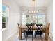 Cozy dining room with a wood table, stylish chandelier, and bright window views at 1844 Odiorne Point Ln, Wesley Chapel, FL 33543