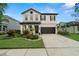 Charming two-story home featuring a landscaped yard, two-car garage, and a basketball hoop on the driveway at 1844 Odiorne Point Ln, Wesley Chapel, FL 33543