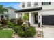 Inviting home exterior with a well-manicured front yard, a covered front porch, and a black two-car garage at 1844 Odiorne Point Ln, Wesley Chapel, FL 33543