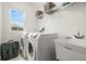 Functional laundry room with modern washer and dryer, utility sink, and storage shelves at 1844 Odiorne Point Ln, Wesley Chapel, FL 33543
