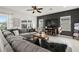 Comfortable living room featuring a modern sectional couch, dark accent wall, and natural light at 1844 Odiorne Point Ln, Wesley Chapel, FL 33543