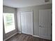 A sunlit bedroom featuring hardwood-style floors, a closet, and neutral-toned walls at 2216 4Th Sw St, Ruskin, FL 33570