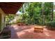 Spacious brick patio with lush landscaping, benches, and an inviting outdoor space at 2279 Ranchette Ln, Dunedin, FL 34698