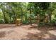 Large backyard featuring a wooden swing set and lush, mature trees at 2279 Ranchette Ln, Dunedin, FL 34698