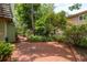 Backyard brick patio surrounded by tropical landscaping and black metal fence at 2279 Ranchette Ln, Dunedin, FL 34698