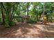 Lush backyard with mature trees, a home exterior, and a swing set at 2279 Ranchette Ln, Dunedin, FL 34698