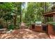 Backyard with brick patio, custom outdoor kitchen, and gazebo surrounded by lush landscaping at 2279 Ranchette Ln, Dunedin, FL 34698