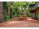 Brick patio with gazebo and an upper porch surrounded by green trees at 2279 Ranchette Ln, Dunedin, FL 34698