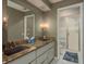Bathroom with double sink vanity, granite counters, large mirror and a shower with glass doors at 2279 Ranchette Ln, Dunedin, FL 34698