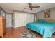 Bedroom features hardwood floors, ceiling fan, closet, a blue bed, and a decorative rug at 2279 Ranchette Ln, Dunedin, FL 34698